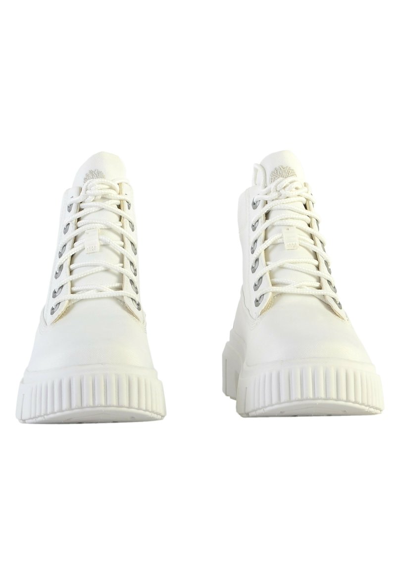 Zapatillas altas blancas con material sintético texturizado, puntera redonda, suela de plataforma en contraste y ojales metálicos para los cordones.