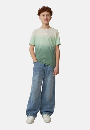 Groene en witte gradient t-shirt met korte mouwen, gecombineerd met wijde lichtblauwe jeans en witte sneakers. Eenvoudig logo detail op het shirt.