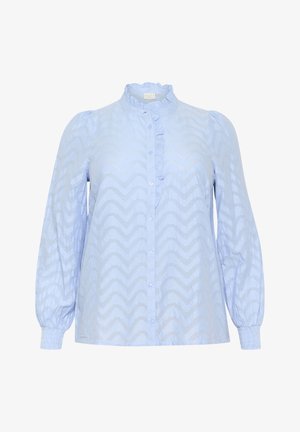 Blouse bleue à motif avec un col volanté, une fermeture à boutons sur le devant et de longues manches bouffantes avec des poignets élastiques. Motif en chevrons texturé sur l'ensemble.