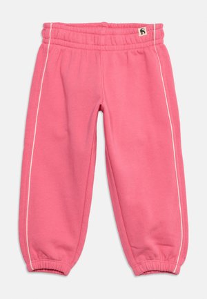 Pink children's sweatpants with elastic waistband and cuffs, featuring white side piping and a small monkey logo tag near the waist.