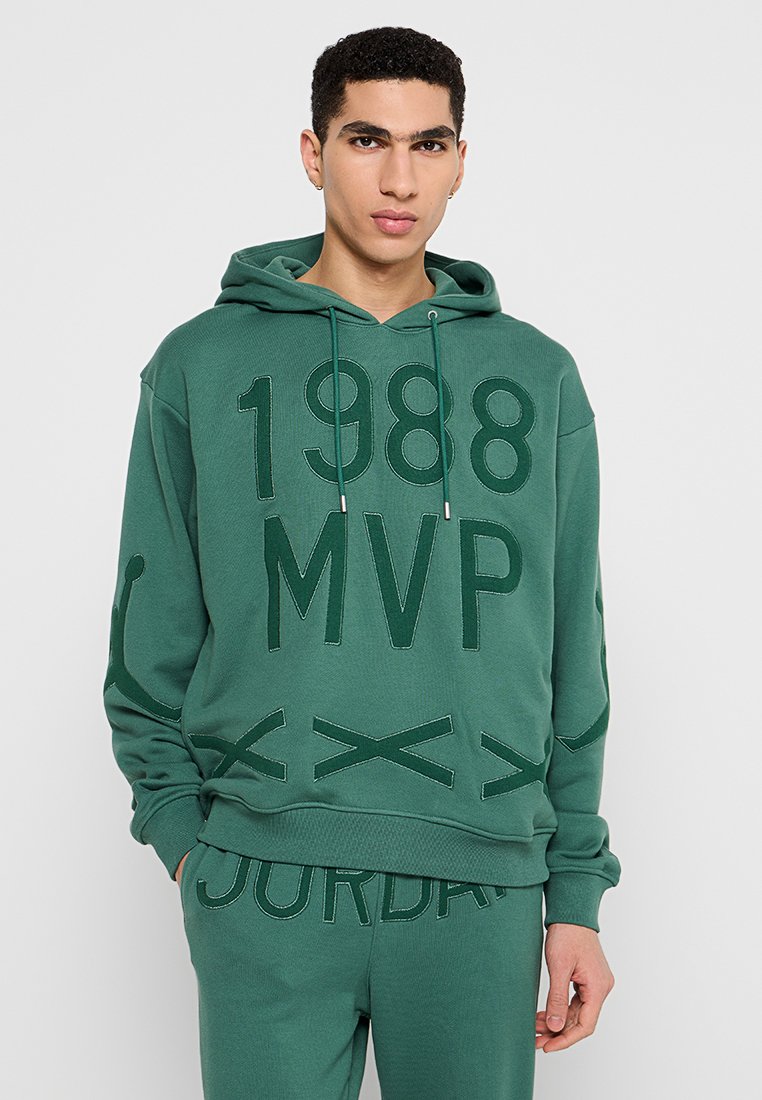 Sweatshirt vert avec capuche, présentant un texte audacieux "1988 MVP" et "JORDAN" dans une texture contrastante. Tissu doux et coupe décontractée.
