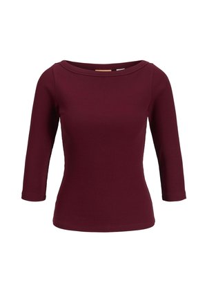 Haut bordeaux côtelé à manches trois-quarts et encolure large. Le tissu semble lisse et extensible, adapté à un port décontracté.