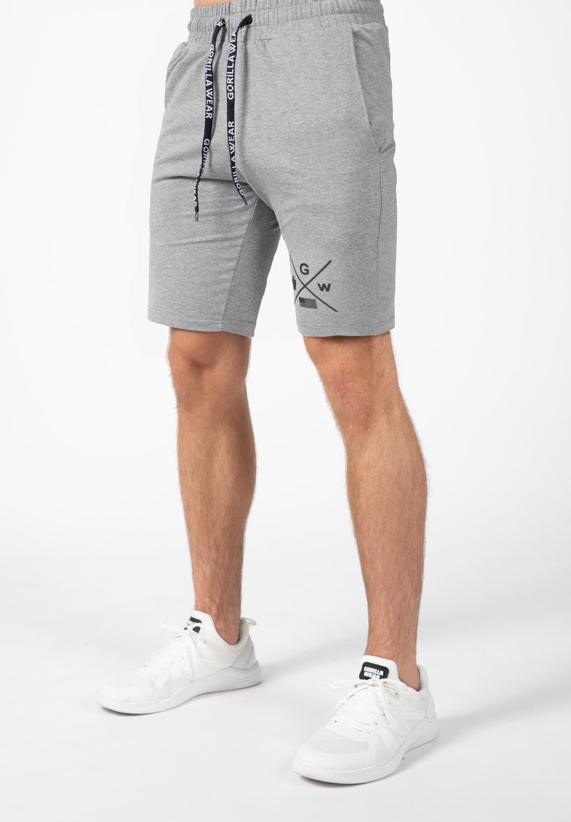 Grijze katoenen shorts met een elastische tailleband en koord, voorzien van zijzakken en een zwart grafisch logo op de linker dij.