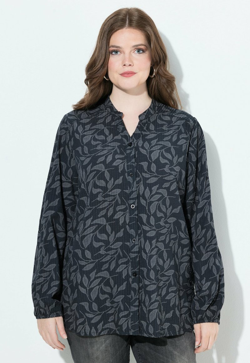 Donkere, gemusterde blouse met knoopsluiting en een mandarinnekraag, met een bladontwerp in grijs op een marineblauwe achtergrond. Lange mouwen, relaxte pasvorm.