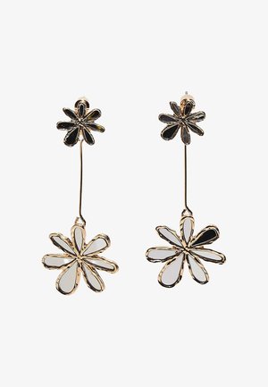 Ohrringe mit goldfarbener Oberfläche und Hängeelementen, bestehend aus zwei verbundenen Blumenformen mit weißen und schwarzen Emaille-Blütenblättern in einem abstrakten Design.