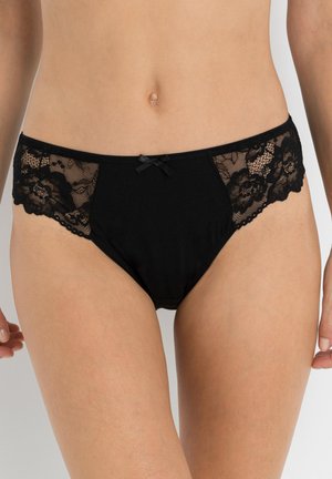 Culotte en dentelle noire et coton présentant un panneau en dentelle florale sur les côtés, un devant et un dos noirs unis, ainsi qu'un petit nœud au centre comme accent.