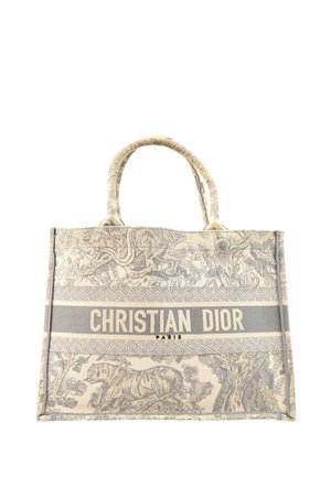Bolso tote beige y gris de Christian Dior con estampado de animales y naturaleza, dos asas y texto "Christian Dior Paris" en la parte delantera.