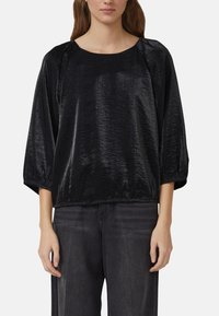 Schwarzes, glänzendes Pullover-Top mit lockerer Passform, rundem Ausschnitt und dreiviertel Ärmeln; hergestellt aus texturiertem Material mit dezentem Glanz.