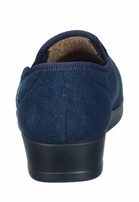 Navy blue suede slip-on shoe with black textured sole and brown fuzzy interior lining, shown from the back.