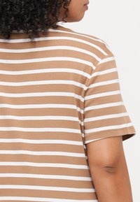Camiseta de rayas marrón y blanca de manga corta, material de algodón suave, cuello redondo y corte regular, mostrando la vista trasera.