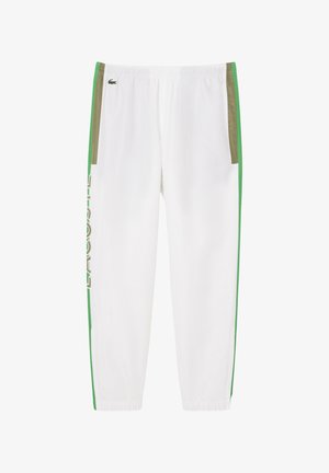 Pantalones deportivos blancos con franjas laterales verdes y acentos de bolsillo en caqui. Presentan una cintura con cordón y un logo impreso en el costado.