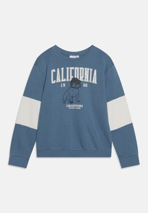 Niebieska bluza z białymi paskami na rękawach, tekstem "CALIFORNIA 1986" oraz ilustracją buldoga nad napisem "CHAMPIONS COLLEGE LEAGUE" z przodu.