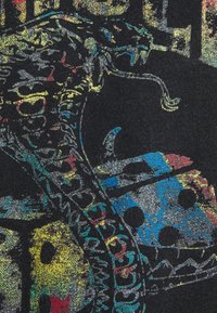 Tela negra con un diseño de serpiente colorido y brillante, con acentos en azul, amarillo y rojo, que muestra patrones y texturas intrincadas.