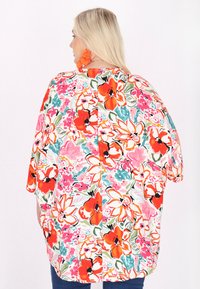 Kwiatowa, lekka bluzka z intensywnymi pomarańczowymi, różowymi i niebieskimi wzorami. Posiada luźny krój i krótkie rękawy. Miękki materiał z kolorowym wzorem.