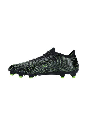 Chaussure de football noire et verte avec des crampons moulés, des lacets et un motif texturé sur la partie supérieure, conçue pour jouer sur terrain ferme.