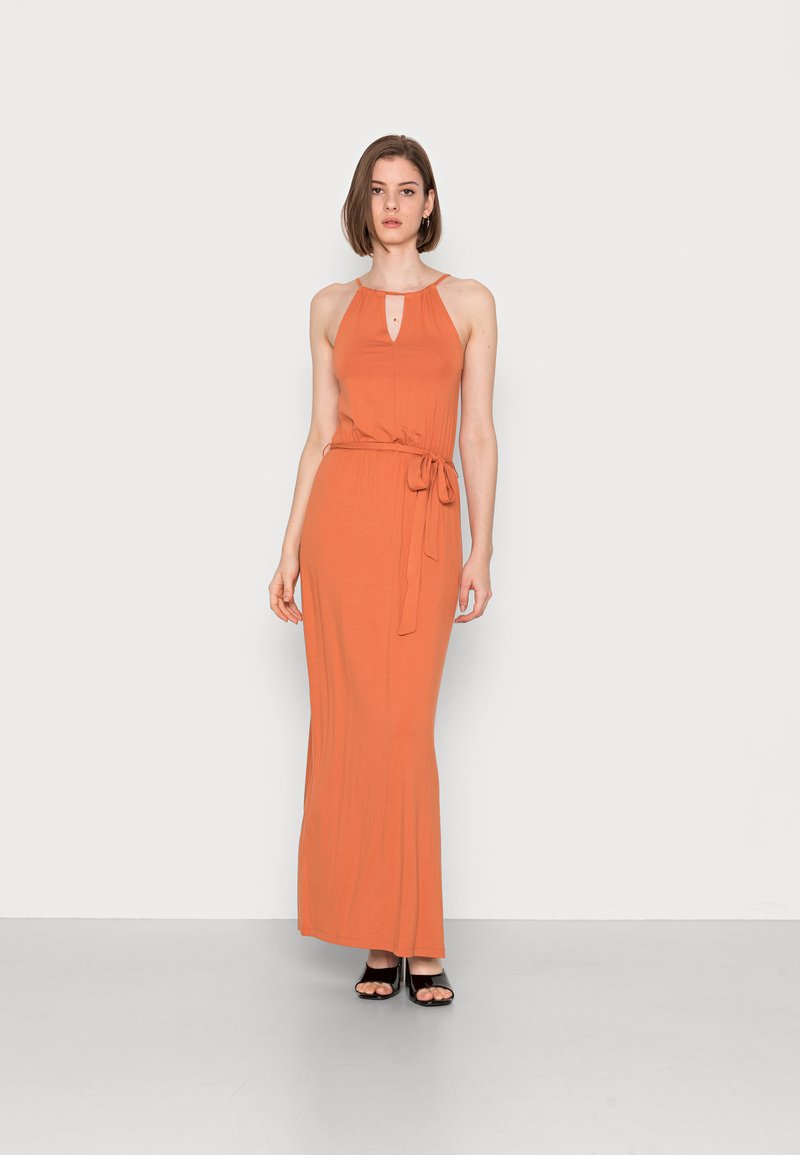 Vestido maxi em tecido laranja queimado com decote halter, recorte em forma de olho-chave e cintura cingida. Textura suave, silhueta ajustada e comprimento até ao chão.