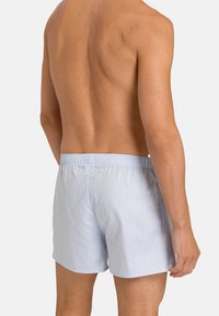 Un maillot de bain bleu clair avec une taille élastique, un tissu lisse et une coupe décontractée. Pas de motifs ou d'accents visibles.