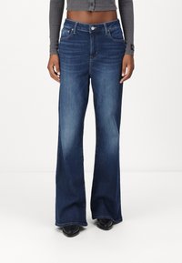 Φαρδιά σκούρα μπλε τζιν παντελόνια με κλασικό σχέδιο πέντε τσέπες, ψηλή μέση και φερμουάρ με κλείσιμο κουμπιού.