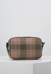 Ruutukuvioinen olkalaukku, jossa on musta, beige ja vaaleanpunainen kuvio, suorakulmainen muoto sekä musta nahkainen hihna ja yksityiskohdat.