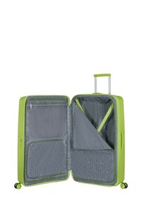 Valigia rigida verde con una superficie testurizzata. Interno in tessuto grigio con motivi geometrici e scomparti con cerniera. Manico estraibile e ruote.