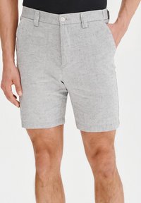 Szare szorty z tkaniny z płaskim przodem, paskami oraz zapięciem na guzik. Gładka faktura z delikatnymi kropeczkami; długość do kolan.
