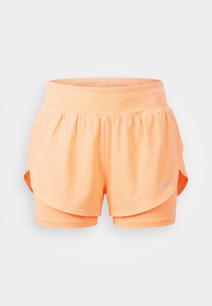 Ανοιχτό πορτοκαλί πολυεπίπεδη αθλητική βερμούδα τρεξίματος με καμπυλωτό τελείωμα και μικρό γκρι λογότυπο Nike στο μπροστινό δεξί πόδι.