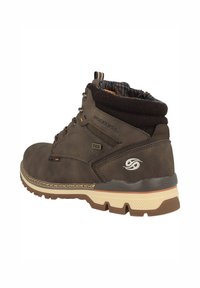 Botas de tobillo de cuero marrón con un cuello acolchado, diseño de cordones, suela texturizada y acentos naranjas, con un logo en el lateral.