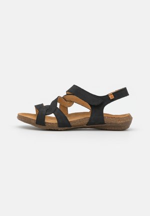 Zwarte sandalen met een crisscross bandontwerp, verstelbare hielband en een bruine textuur inlegzool met een kurkachtige zool.