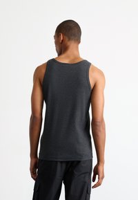 Donkergrijze geribbelde tanktop met brede schouderbanden en een ronde halslijn, weergegeven vanuit de achterkant tegen een effen witte achtergrond.