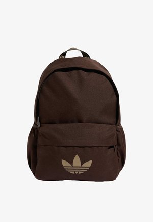 Mochila marrón con bolsillo frontal con cremallera y logotipo beige de Adidas trefoil centrado en el bolsillo, asa de tela en la parte superior.