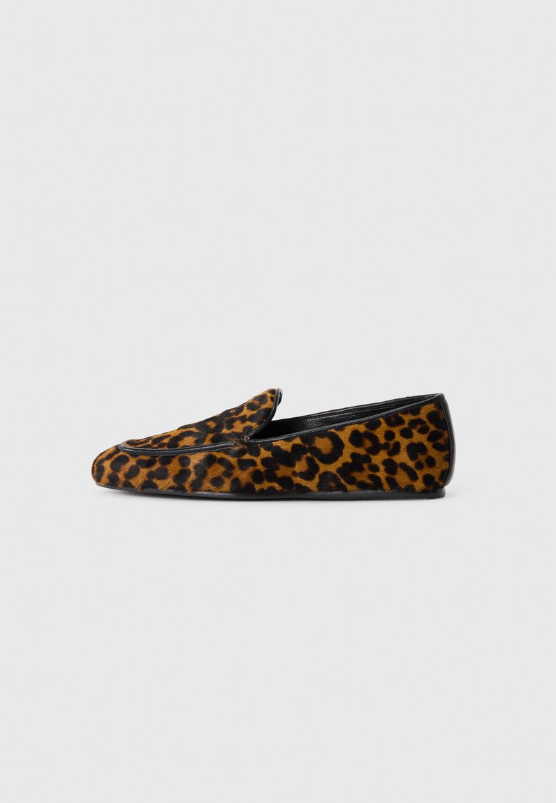 Mocassin plat pour femme avec un imprimé léopard marron et noir, bord noir et style slip-on, présenté sur fond blanc.