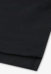 Fekete pamutvászon sima felülettel, hajtott szegéllyel és dupla varrással. Egyszerű kialakítás, látható minták vagy díszítések nélkül.