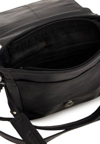 Černá kožená kabelka přes rameno s hladkým povrchem, vnitřní kapsou na zip a předním zapínáním na patentku. Obsahuje dlouhý popruh a minimální hardware.