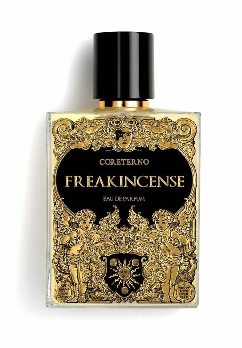 La bottiglia di Eau de Parfum FREAKINCENSE di Coreterno presenta un design in vetro trasparente con intricate decorazioni dorate, accenti neri e un tappo texturizzato.