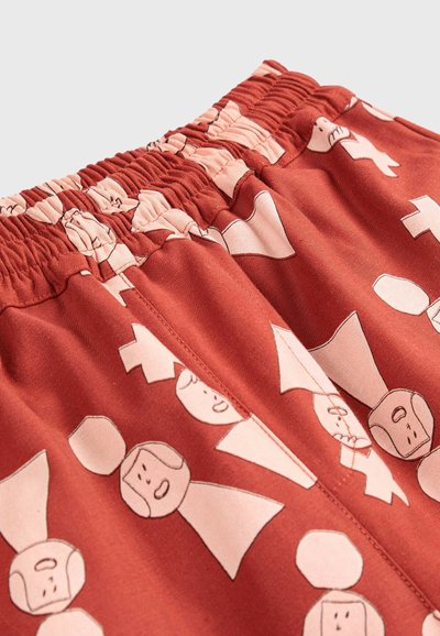 Červené šortky s elastickým pásom, zdobené kresleným vzorom s tvárami a tvarmi v bledoružovej farbe. Vyrobené z mäkkej, hladkej látky.