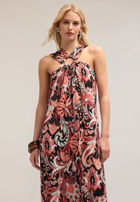 Rochie maxi cu model floral în negru, corai și teal. Dispune de un guler halter înnodat cu o decupare rotundă. Material ușor.