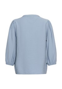 Blouse bleu clair à manches longues avec épaules bouffantes froncées et poignets élastiques, vue de dos sur fond blanc.