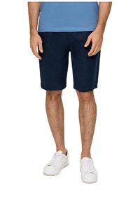 Shorts navy en tissu léger, dotés d'une coupe droite et de poches latérales, associés à des baskets blanches basses.