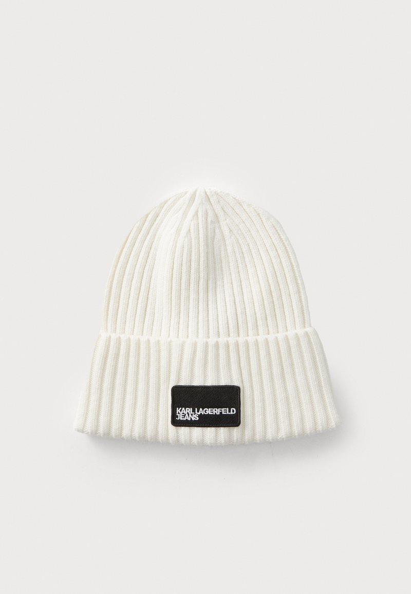 White knit beanie with ribbed texture and folded cuff. Features a black rectangular label with white lettering, "KARL LAGERFELD JEANS."