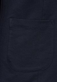 Navyblaues Gewebe mit glatter Textur verfügt über eine genähte Tasche, abgerundete Kanten und sichere Nähte, die für praktische Verwendung entworfen sind.