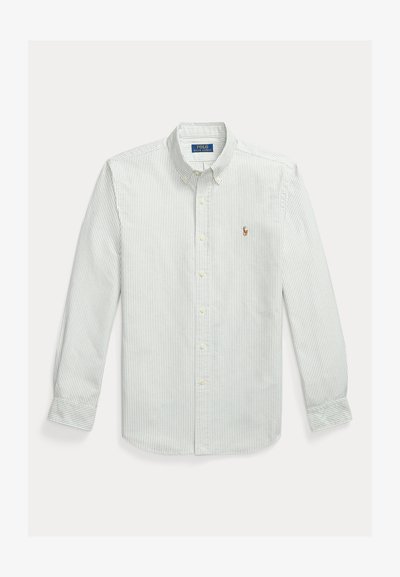 Šviesiai žalia ir balta dryžuota medvilninė marškinėliai su sagomis, su klasikiniu apykakliu ir mažu siuvinėtu logotipu ant krūtinės.