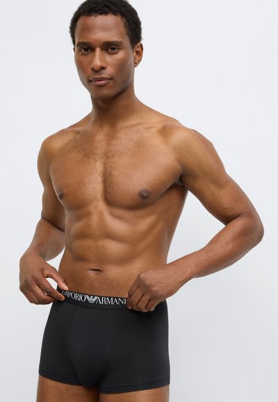 Μαύρα βαμβακερά ανδρικά εσώρουχα μπόξερ με ελαστική μέση που φέρει λευκό λογότυπο "Emporio Armani". Λείο ύφασμα, εφαρμοστή σχεδίαση, μήκος έως τη  μέση του μηρού.