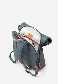 Blauer Rolltop-Rucksack mit braunen Lederakzenten. Verfügt über ein graues Innenfutter, mehrere Fächer und verstellbare Träger. Reißverschluss als Verschluss.