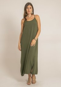 Robe maxi vert olive en tissu doux, avec une coupe décontractée, des bretelles spaghetti et des fentes latérales pour un mouvement accru.