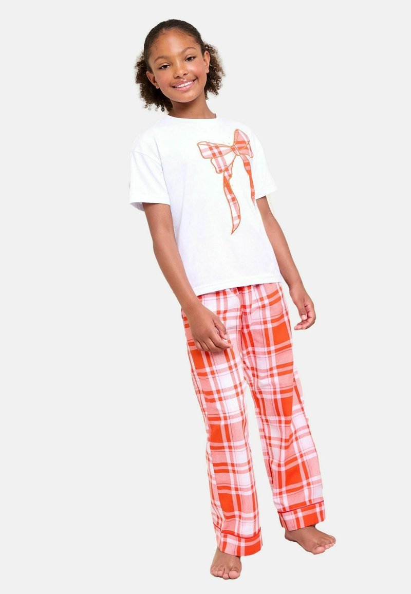 T-shirt bianca a maniche corte con grafica di fiocco a quadri arancioni e pantaloni da pigiama a quadri arancioni. Tessuto morbido, vestibilità ampia, con orli risvoltati.