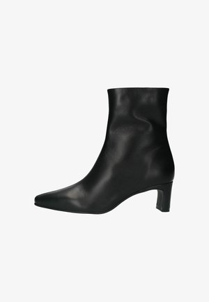 Bottine en cuir noir avec un bout pointu et un talon modéré. Présente une texture lisse et un design épuré, sans fermetures visibles.