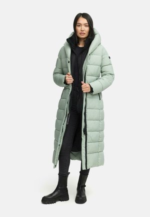 Long, padded coat in mint green with a high collar and hood. Features black zipper closure and side pockets, paired with black pants and boots.