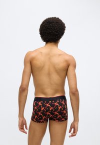 Boxeri negri cu un model floral roșu, croială strâmtă, material neted și talie elastică cu marginile contrastante.