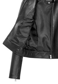 Giacca di pelle nera con esterno liscio, zip lucida e fodera interna in satin. Presenta una silhouette aderente e dettagli di cucitura minimi.