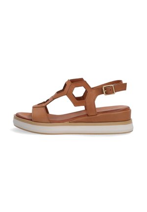 Leather sandal in tan with hexagonal cutouts, adjustable ankle strap, and a layered white sole for cushioning and support.